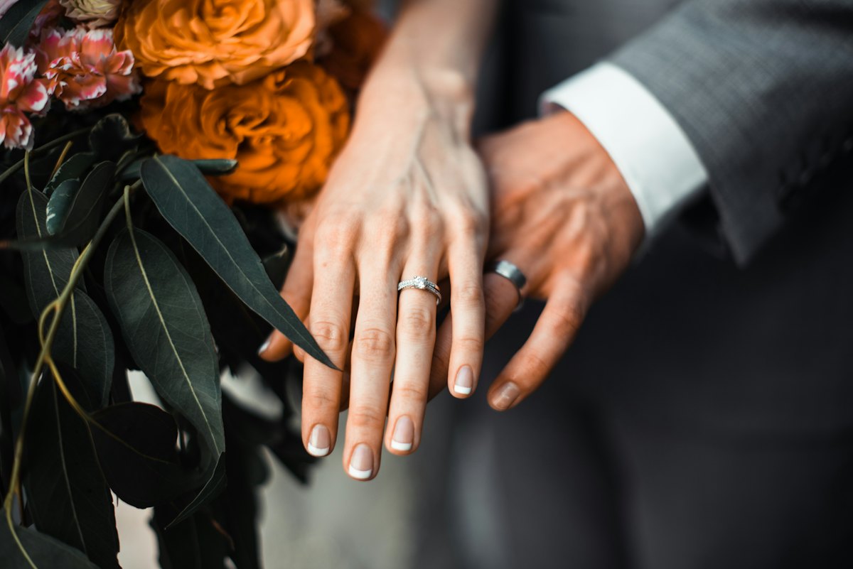 Las manos de los novios con sus alianzas