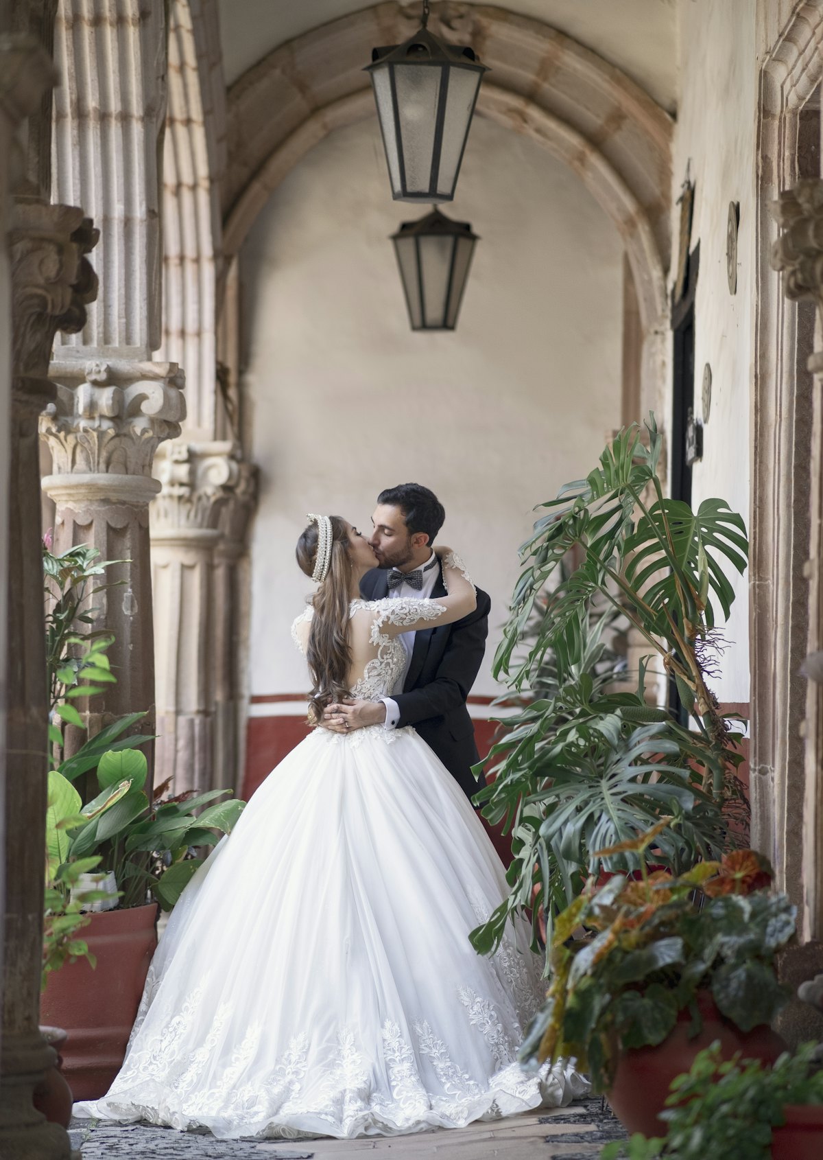 Novios en un patio con arcos